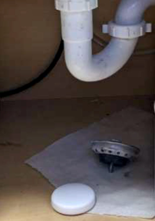 ShieldPro flood detection product displayed under a sink in use with sink pipe